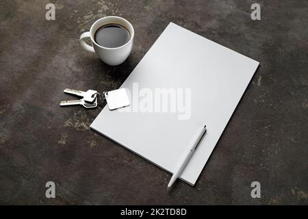 Blank letterhead, coffee cup, key and pen on concrete background. Copy space for text. Stock Photo