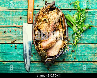 Roast pork in hay with herbs Stock Photo