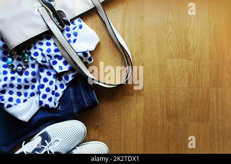 Collection of women's clothes. Jeans, shoes, bluose, glass. Top view Stock Photo