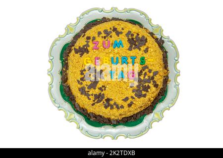 Top view of homemade lemon cake with almonds and chocolate flakes and in German Zum Geburtstag. Clipping path. Isolated on white background. Space. Stock Photo