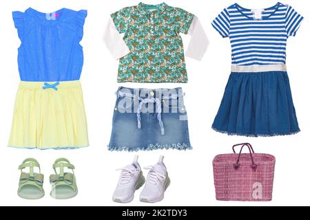 Collage set of little girls summer clothes isolated on a white background. The collection of stylish dresses, a jeans or denim skirt, shoes and a bag.  Children's spring and autumn fashion. Stock Photo
