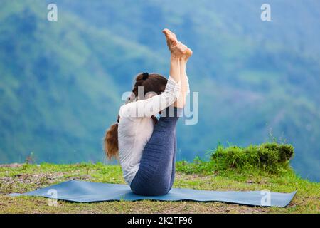 Woman practices yoga asana Urdhva mukha paschimottanasana Stock Photo