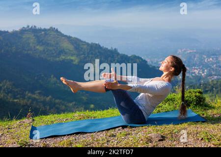 Woman doing Ashtanga Vinyasa Yoga asana Navasana - boat pose Stock Photo