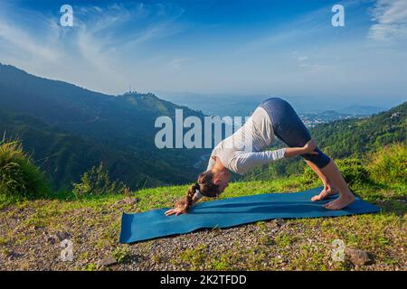 Young sporty fit woman doing yoga oudoors in mountains Stock Photo