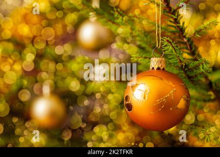 Decoration bauble on decorated Christmas tree background Stock Photo