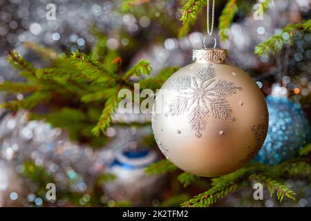 Decoration bauble on decorated Christmas tree background Stock Photo