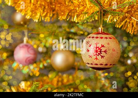 Decoration bauble on decorated Christmas tree background Stock Photo
