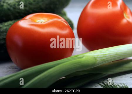 Cucumbers, tomatoes, green onions close-up. The concept of vegetarianism, healthy eating. Stock Photo