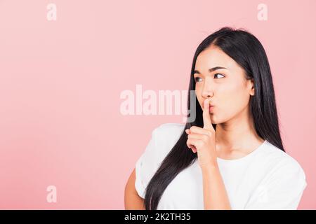 woman smile stand making finger on lips mouth silent quiet gesture Stock Photo
