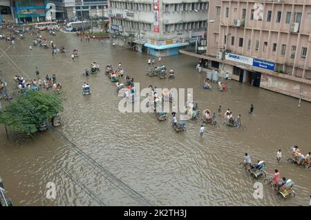 Dhaka, Bangladesh - July 28, 2009: Vehicles try to drive through a flooded street in Dhaka, Bangladesh. Encroachment of canals is contributing to the Stock Photo