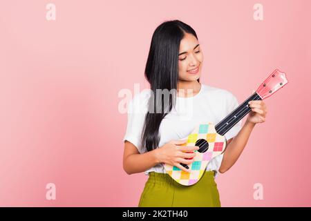 woman teen confident smiling face hold acoustic Ukulele guitar Stock Photo