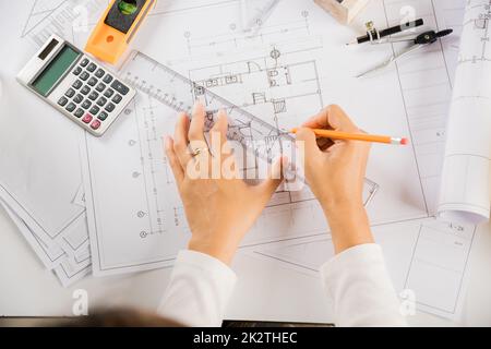 Architect drawing with ruler on house plan blueprint paper for repair tools on table Stock Photo