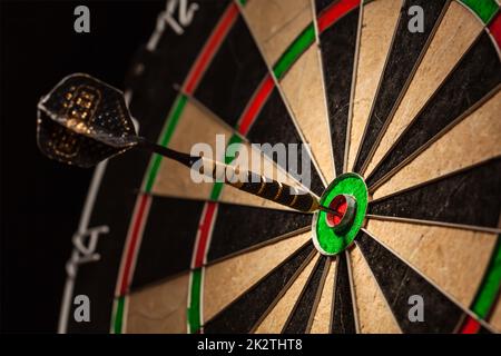 Dart in bull's eye close up Stock Photo