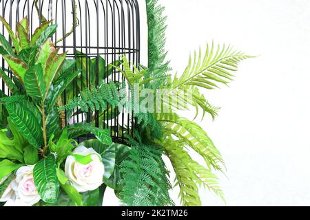 colorful flower and green paln leaves  in cage hanging decoration Stock Photo