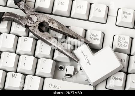 Pliers with ENTER key laying on the keyboard Stock Photo