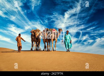 Two cameleers camel drivers with camels in dunes of Thar desert Stock Photo