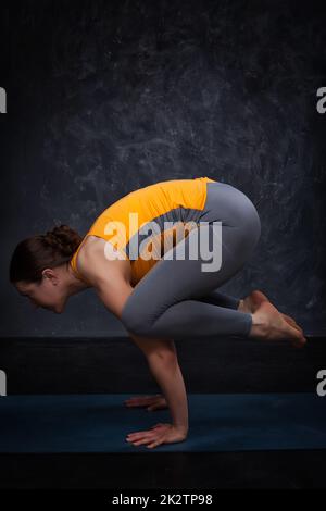 Beautiful sporty fit yogini woman practices yoga asana kakasana Stock Photo