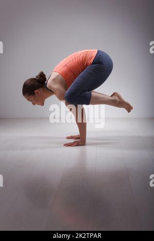 Beautiful sporty fit yogini woman practices yoga asana kakasana Stock Photo