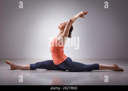 Sporty fit woman doing yoga asana Hanumanasana Stock Photo