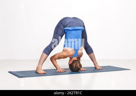 woman doing yoga asana prasarita padottanasana 2k2tr1c