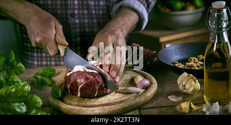 Crop male cutting cabbage on table Stock Photo