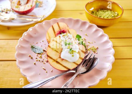Ripe grilled nectarines with yogurt on plate Stock Photo