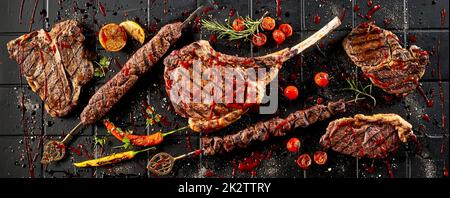 Grilled steaks covered with tomato sauce placed on table Stock Photo