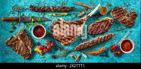 Appetizing grilled meat steaks placed on table Stock Photo