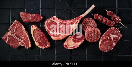 Assorted raw steaks near cutlets and shish kebab Stock Photo