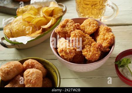 Delicious fried chicken pieces and potato chips on table Stock Photo