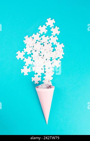 Cone with white puzzle pieces, blue background, spreading the jigsaw parts, searching for ideas and solutions, brainstorming as a team, flat lay Stock Photo