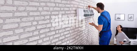 Technician Repairing Air Conditioner With Digital Multimeter Stock Photo