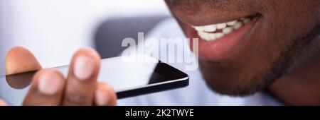 Man Using Voice Assistant On Cellphone Stock Photo