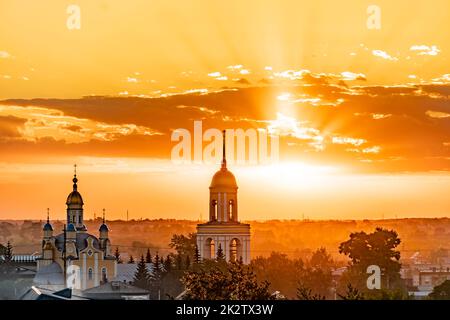 Golden domes with Orthodox crosses on the church.Temple or cathedral on the background of an evening sunset with a golden sky. A lonely church at dusk with sunset clouds.Golden Hour,skyline,horizon Stock Photo