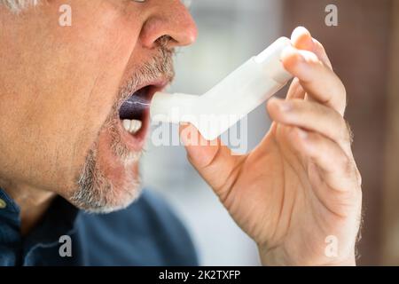 Man Using Asthma Inhaler Stock Photo