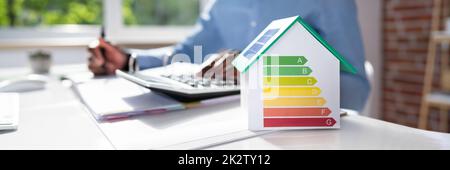 Businessman Calculating House Energy Cost Stock Photo