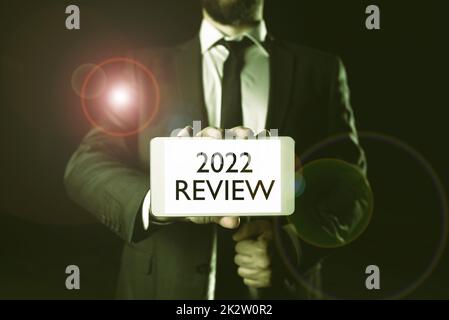 Handwriting text 2022 Review. Word Written on seeing important events or actions that made previous year Lady in suit holding pen symbolizing successful teamwork accomplishments. Stock Photo