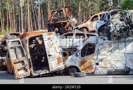 A lot of rusty burnt cars in Irpen, after being shot by the Russian military. Russia's war against Ukraine. Cemetery of destroyed cars of civilians who tried to evacuate from the war zone. Stock Photo