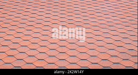 New roof with red shingles. Tiles on the roof of the house. Use to advertise roof fabrication and maintenance. Spotted texture. Affordable roofing. High quality photo with copy space. Stock Photo