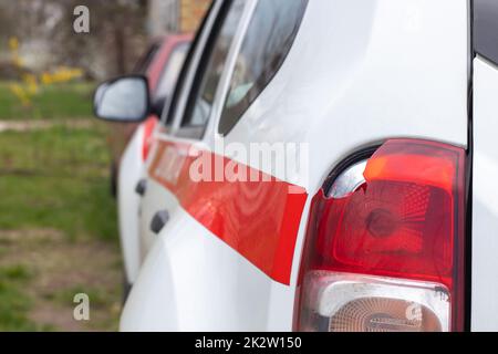 The rear left lamp of a white car is broken. The taillight of the car was shattered in the accident. Damage accident. Security concept. Rear stop of a car in an accident close-up. Stock Photo