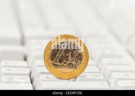 One euro coin on white computer keyboard background Stock Photo