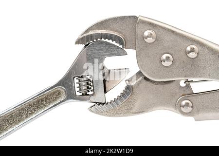 Big adjustable wrench squeezing small adjustable wrench Stock Photo