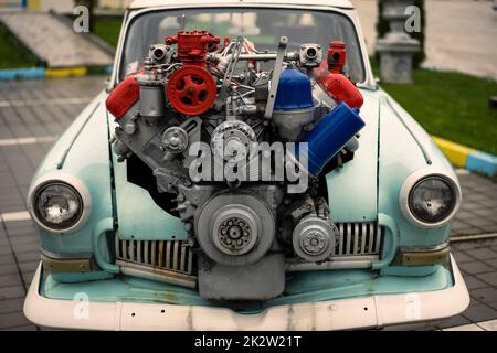 Vintage tuned car, with a large engine sticking out of its hood Stock Photo