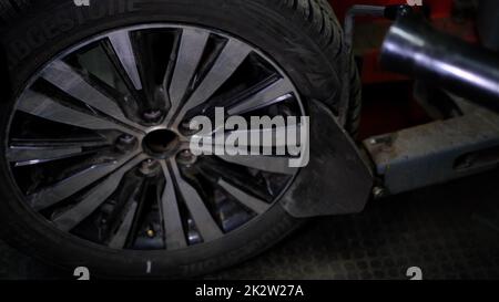 Repair service for wheel tire of car. Removing the tire from alloy disk outside with special machine in servise station Stock Photo