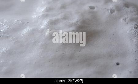 Steam or vapor clouds rising from boiling water with clotted foam and bubbles Stock Photo