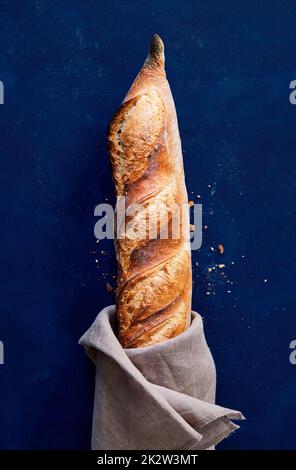 Freshly baked baguettes on a blue background. Stock Photo