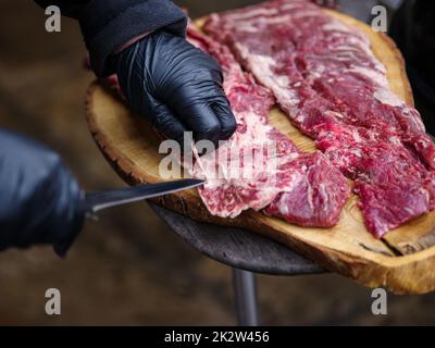 Raw hanging tender or onglet steak of beef on wooden Board. Preparing meat for barbecue grilling. BBQ. Stock Photo