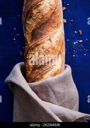 Close-up of a freshly baked baguette on a dark blue background Stock Photo