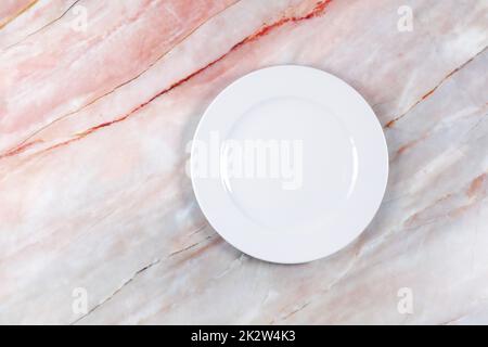 Dinner plate on a pink white and grey marble surface Stock Photo