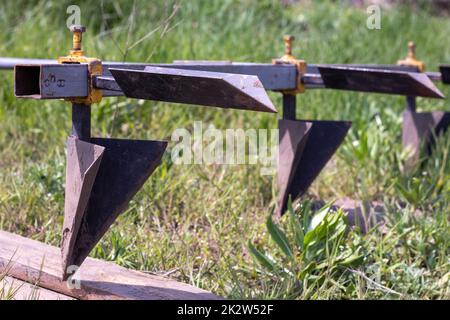 Agricultural manual metal plow on the field. Plowing the land before sowing. Close-up. Inventory for plowing potatoes in the countryside. A plow is a tool for plowing dense soil, raising virgin soil. Stock Photo